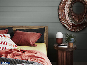 Grey Wooden Panels on a Bedroom Wall with Dusty Red Pillows